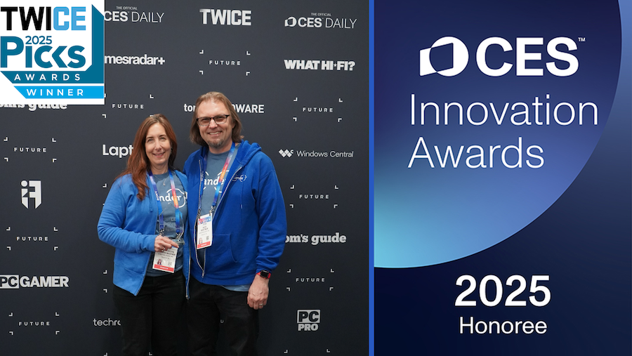 woman and man hold award, standing side by side in from of award banner