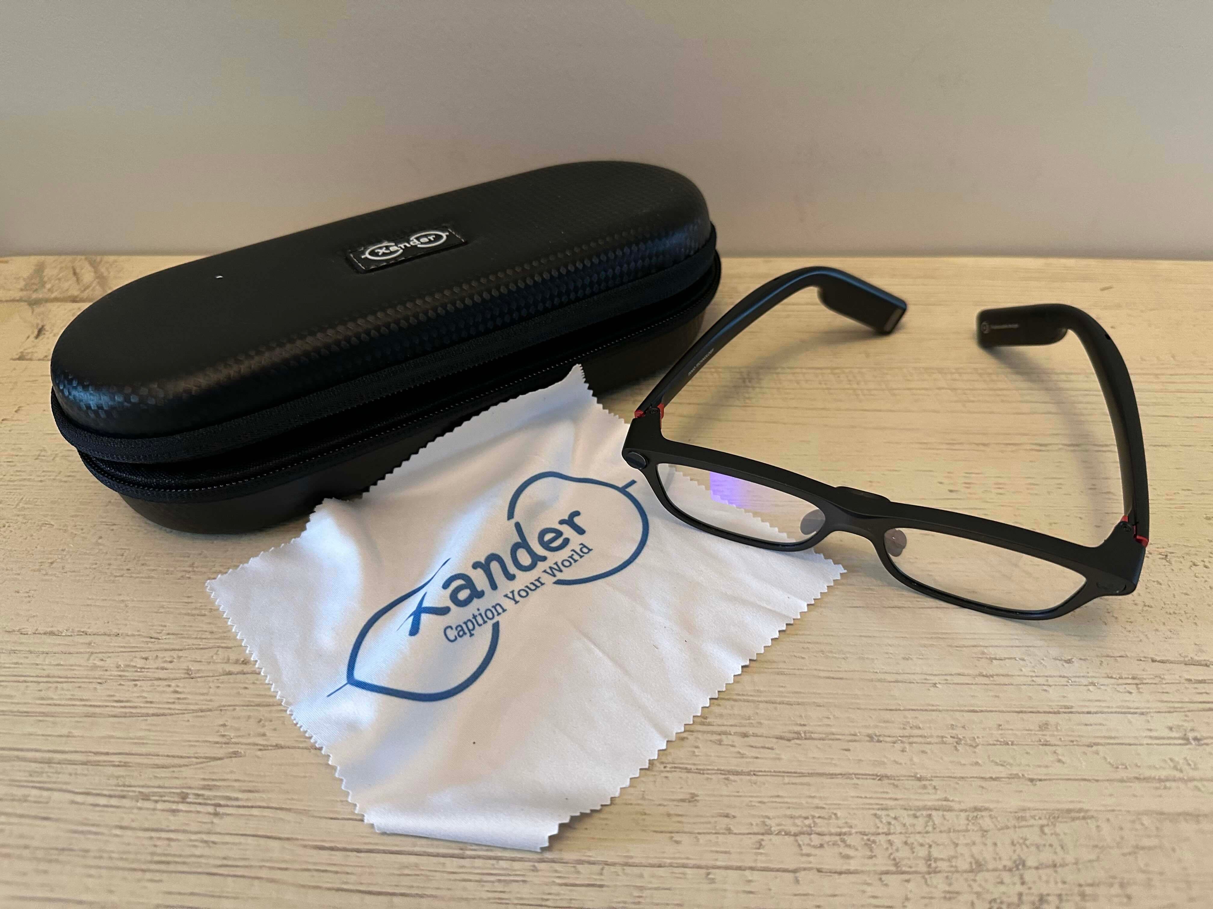 small black case, eyeglasses and cleaning cloth on table